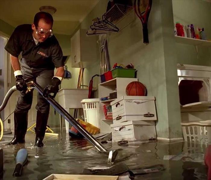 SERVPRO employee extracting water out of a flooded basement 